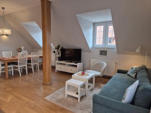 カジミエシュ・ドルニにあるAPARTAMENTY TUŹNIKOWIEの青いソファとテーブルのあるリビングルーム