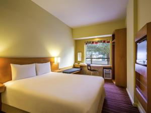 a hotel room with a large bed and a window at ibis Mall Avenue Dubai in Dubai