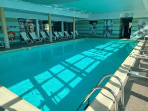 a large swimming pool with chairs in a building at Maison 3 piscines - Résidence 3 étoiles in Pornichet
