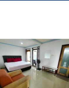 a bedroom with a bed and a couch and a table at Toraja Sanggalangi Homestay in Rantepao