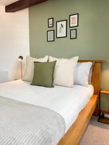 a bedroom with a large bed with white pillows at Borders Retreat, Cosy 1 Bed Flat - 3miles from M6 Jct45 - near A75, Gretna & Carlisle in Longtown