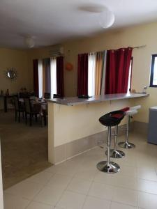 una cocina con barra y un bar con sillas en Silva house bilene, en Vila Praia Do Bilene