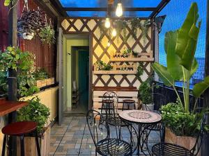ハノイにあるHanoi Quarter Life Hostelのパティオ(テーブル、椅子、植物付)