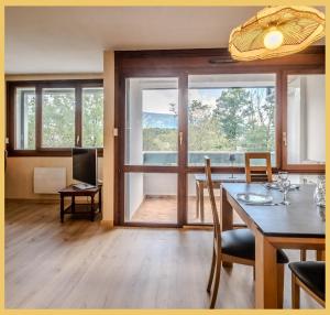 a dining room with a table and a large window at Chez Isabelle & Urbain I T3 I Saint-Julien in Saint-Julien-en-Genevois