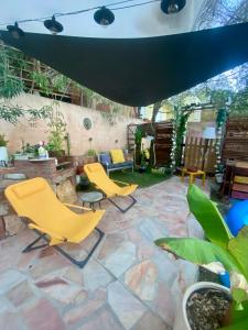 a patio with yellow chairs and a stone floor at Studio Smart&Cosy in Porto-Vecchio