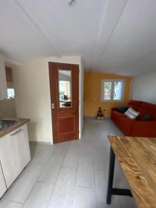 a living room with a red couch and a wooden door at Studio Smart&Cosy in Porto-Vecchio