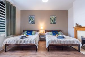 two beds sitting next to each other in a bedroom at 5BR - House - Hot Tube - Airport - A38-A50 - Parking in Burton upon Trent
