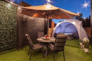 a table and chairs under an umbrella in a yard at 5BR - House - Hot Tube - Airport - A38-A50 - Parking in Burton upon Trent
