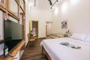 a bedroom with a large bed and a flat screen tv at The Silver Lantern Hanoi-Urban Escape with Balcony Access-Coffee 24-7 in Hanoi