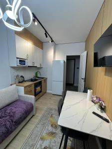a kitchen and a living room with a table and a couch at Stylish apartment & Perfect choice for Travellers in Almaty +3 photos
