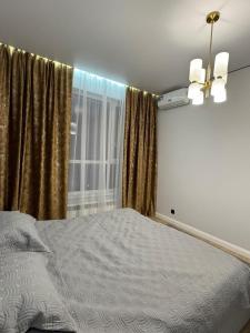 a bedroom with a bed in front of a window at Stylish apartment & Perfect choice for Travellers in Almaty