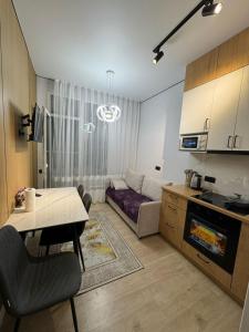 a kitchen and living room with a table and a couch at Stylish apartment & Perfect choice for Travellers in Almaty