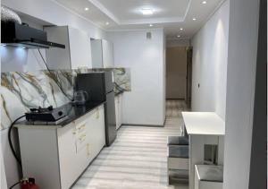 a kitchen with white cabinets and a counter top at Hostel Markaz in Khorog
