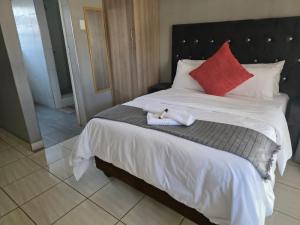 a bed with a stuffed animal sitting on top of it at House 224 Lodge in Driekop +2 photos