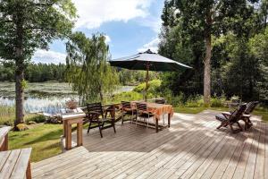 a wooden deck with a table and an umbrella at SKA676-Immeln-Breanaes-3004 in Breanäs