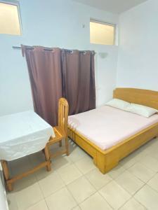 two beds and a chair in a room at Maison Calme, Chambre Privée Calavi in Abomey-Calavi