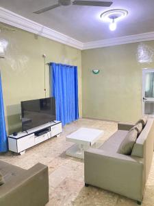 a living room with a couch and a flat screen tv at Maison Calme, Chambre Privée Calavi in Abomey-Calavi