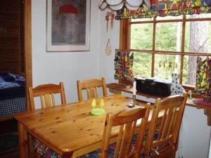 a wooden table in a kitchen with chairs and a window at ORE758-Ramsberg-Persbovaegen-18 in Ramsberg