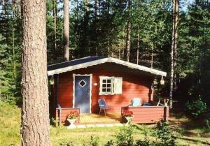 a small cabin with a porch in the woods at ORE758-Ramsberg-Persbovaegen-18 in Ramsberg