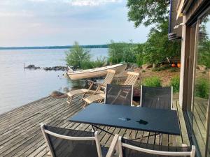 a table and chairs on a deck with a boat at SKA712-Hoerby-Osby-Strandvaegen-120 in Osbyholm