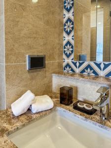 une salle de bain avec une baignoire blanche et un lavabo dans l'établissement Luxury Ozone Bang Tao 1 Bdr, à Laguna Phuket