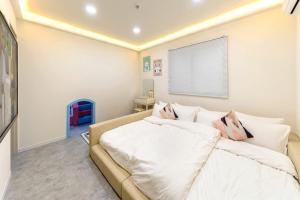 a bedroom with a white bed and a couch at Gapyeong BB Kids Pool Villa in Sŏri-gol +12 photos