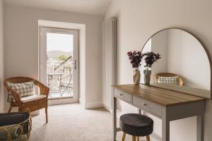 a room with a desk with a mirror and a chair at Tyson Place, 2 bed Renovated Apartment, Ambleside in Ambleside