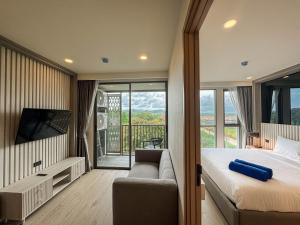 - une chambre avec un lit, un canapé et un balcon dans l'établissement Luxury Ozone Bang Tao 1 Bdr, à Laguna Phuket