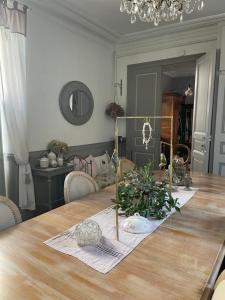 a dining room with a wooden table with plants on it at 2 DESCARTES in La Flèche
