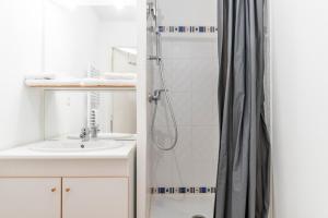 un baño con ducha y lavabo en Well-equipped studio with balcony, en Séné