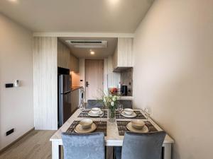 une cuisine avec une table avec deux chaises et une cuisine sidx sidx sidx dans l'établissement Luxury Ozone Bang Tao 1 Bdr, à Laguna Phuket