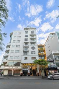 a tall white building on a city street at A25 Hotel - 274 Đề Thám in Ho Chi Minh City