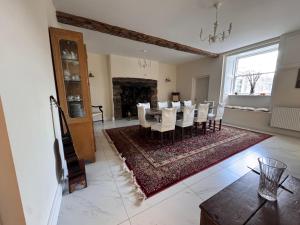 ein Esszimmer mit Tisch und Stühlen und einem Kamin in der Unterkunft Cae Nest Hall in Llanbedr