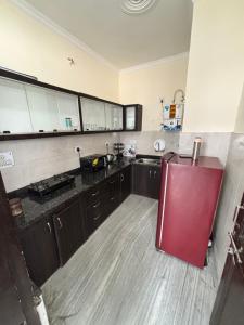 a large kitchen with a red refrigerator in it at Ganga view by Bella Boho in Rishīkesh