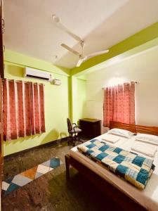 una camera da letto con un letto e una sedia di Anand's Elegant 2BHK Apartment - AC a Mysore