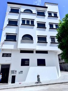 a white building with black windows at TOP Nour D'asilah in Asilah