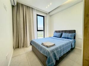 a bedroom with a bed with blue sheets and a window at GSS - 2 Bedroom Apartment in Tbilisi City