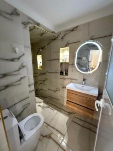 a bathroom with a toilet and a sink and a mirror at TOP Nour D'asilah in Asilah +35 photos