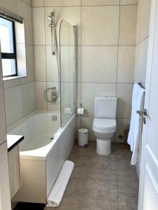兰格班Casa del Mar - Huisie by die See的带浴缸、马桶和淋浴的浴室