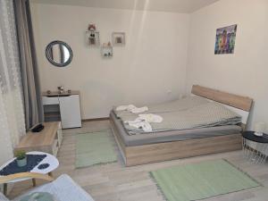 a small bedroom with a bed and a table at Peshtera Cozy Apartment in Peshtera