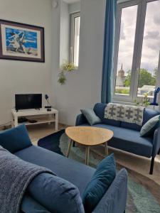 a living room with a blue couch and a table at Quiet duplex in historic town centre in Perros-Guirec
