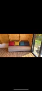 a couch with four different colored pillows in a room at Potpuni Mir in Petrovaradin