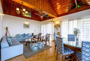 a living room with a couch and a table at Samprati 3BR Villa with Balconies, Homecook & Pet Stay in Kasauli