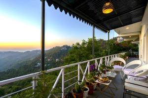 a balcony with a table and chairs and a view at Samprati 3BR Villa with Balconies, Homecook & Pet Stay in Kasauli