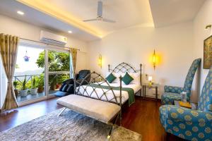 a bedroom with a bed and a chair and a window at Samprati 3BR Villa with Balconies, Homecook & Pet Stay in Kasauli