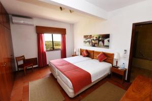 a bedroom with a large bed and a window at Praia da Lota Beachfront Resort - Hotel & Apartments in Manta Rota +61 photos