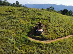 a truck parked on a hill in a field at prince's place cabins and camping in Badulla