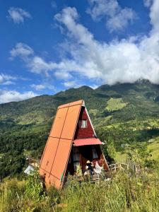 an orange roofed house on top of a hill at prince's place cabins and camping in Badulla