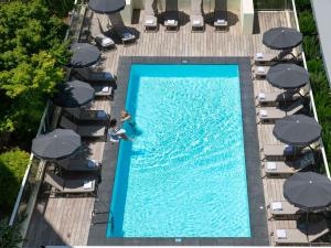 ニースにあるノボテル スイーツ ニース エアポート のスイミングプールの水泳を楽しめる女性の頭上の景色