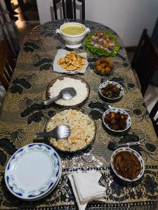 a table with plates and bowls of food on it at Shalom place in Bandarawela